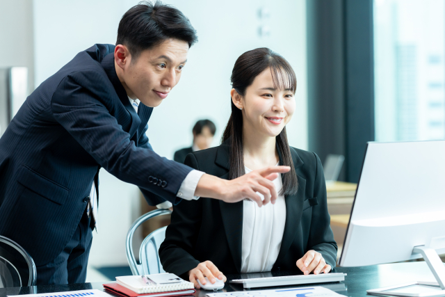 不動産会社の店舗でパソコン画面を見ながら課題を一緒に確認するFDEエンジニア